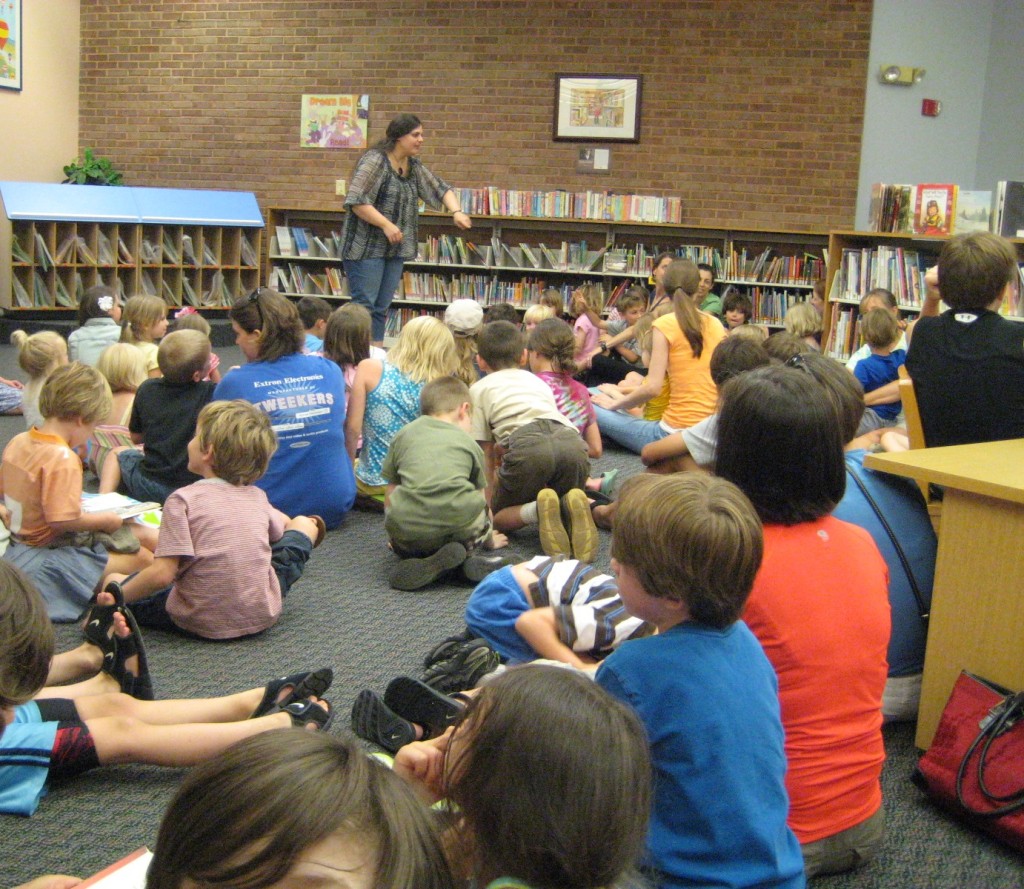 A library with children of various ages sitting on the floor listening to a woman with brown hair and fair skin talk.
Dr. Jennifer Horn, of King's College and currently a professor of English at Pellissppi State University, talks to children about Shakespeare, Theatre, and Story Telling at Mcghee-Tyson Library in Knoxville, TN.